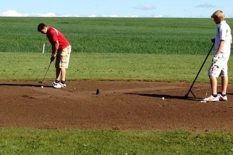 Photo of golfers putting at Tipton Oaks golf course located in Tipton Kansas, in Mitchell County Kansas.
